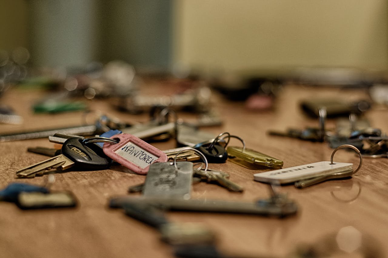 Macro shot of various metallic keys scattered on a wooden surface.